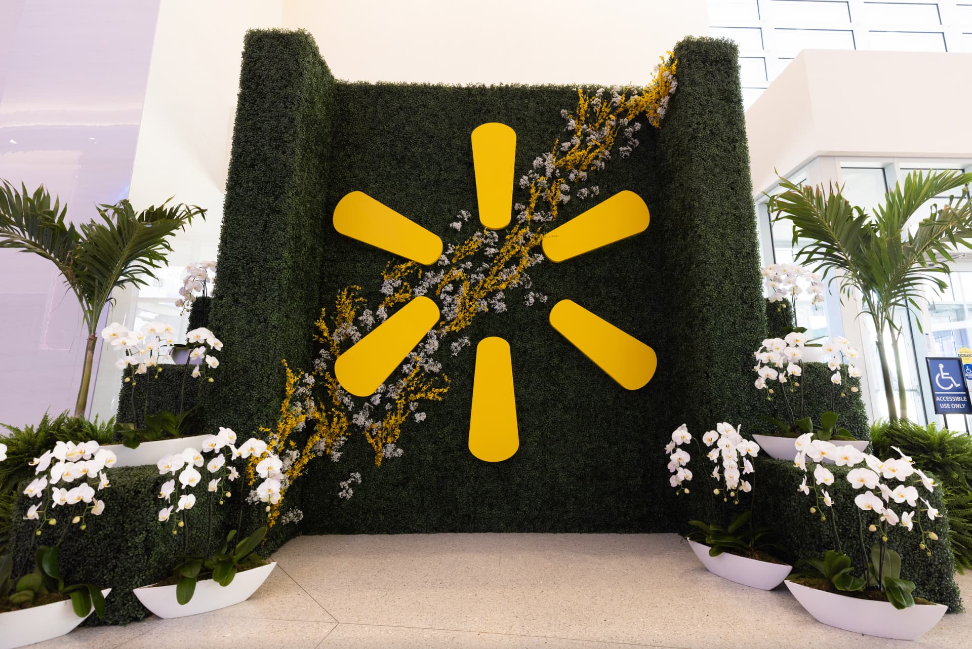 custom greenery wall with dimensional logo and floral accents
