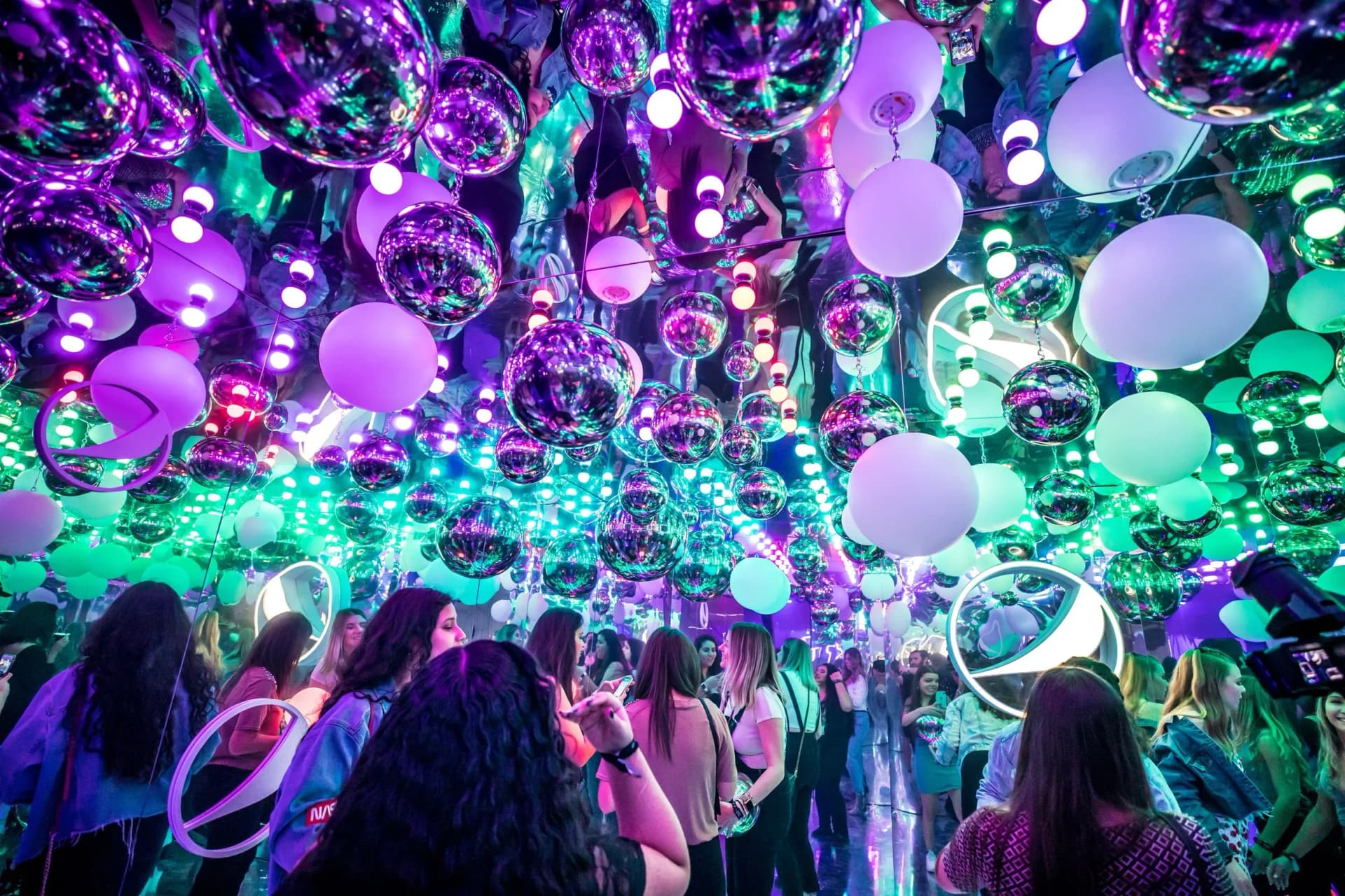immersive event installation with mirrored ceiling and hanging spheres