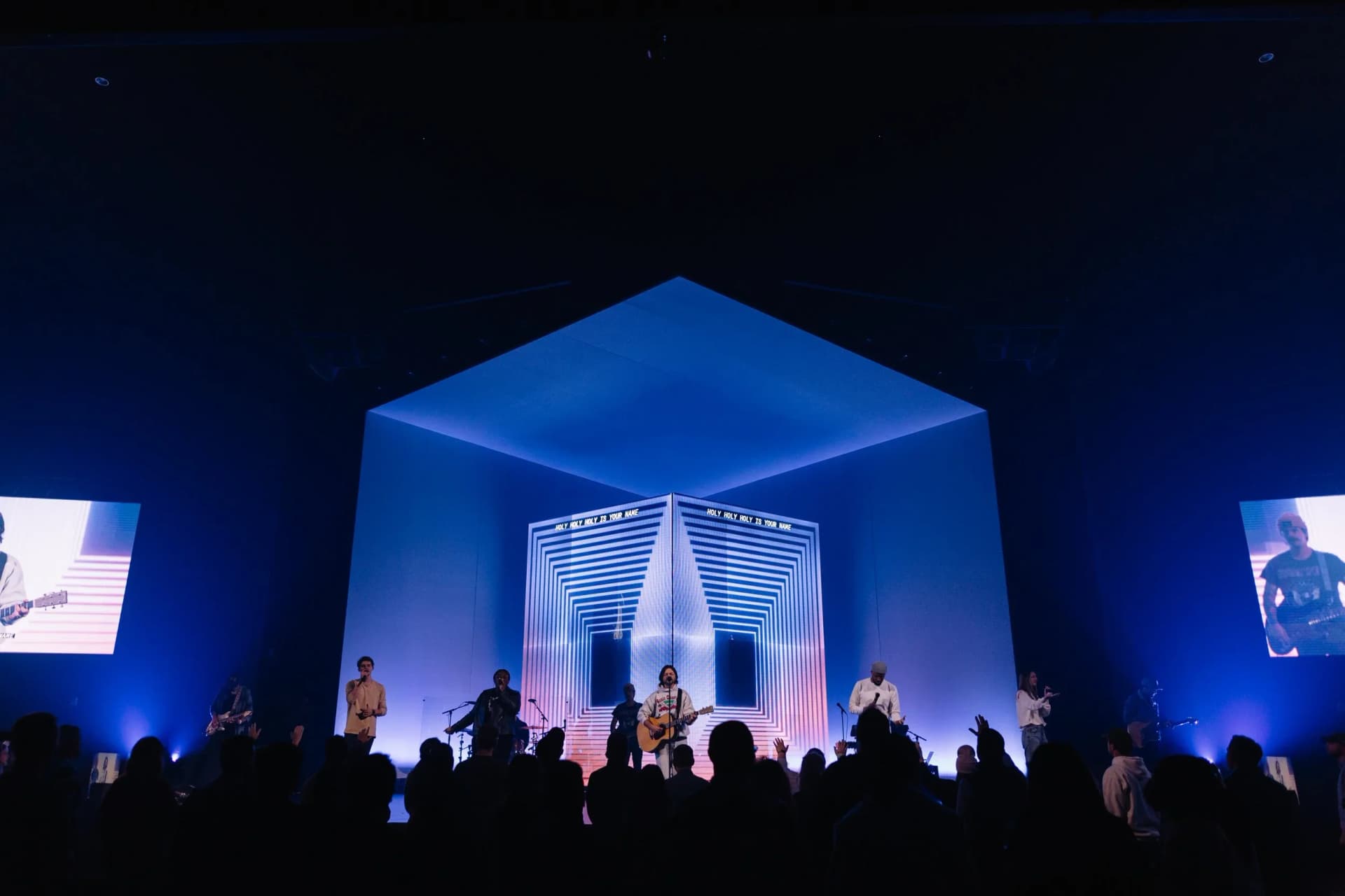 large geometric stage portal with projection mapping and blue event lighting
